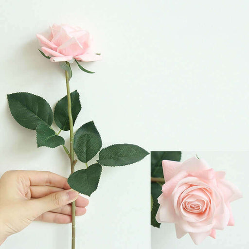 Latex real-touch artificial rose stems with pink petals and green leaves held in hand, showcasing realistic design.