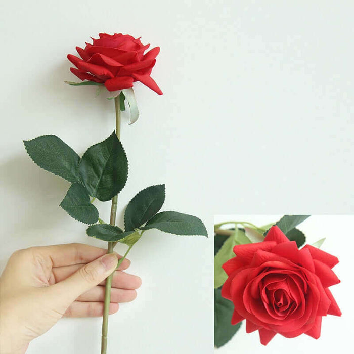 Latex real-touch artificial rose stems held in hand, featuring vibrant red petals and realistic green leaves.