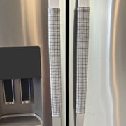 Stainless steel refrigerator with light grey checkered handle covers 