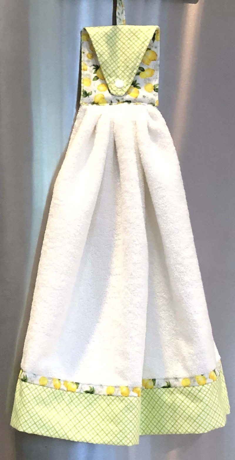 Pastel Mint Green & Lemon Print-Reversible Refrigerator Handle Covers hanging on a stainless steel fridge.