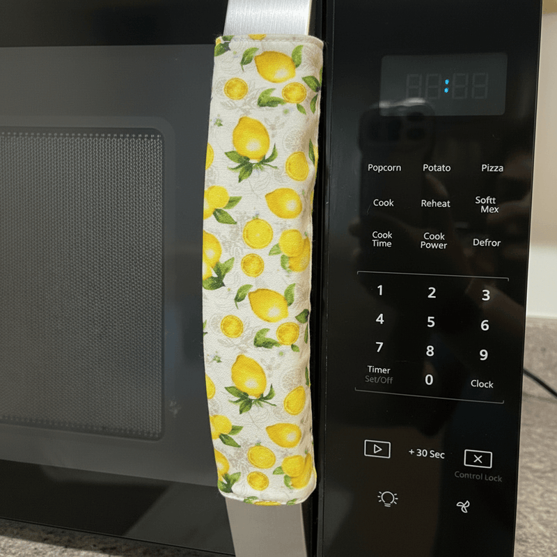 Pastel Mint Green & Lemon Print-Reversible Refrigerator Handle Covers on a microwave handle.