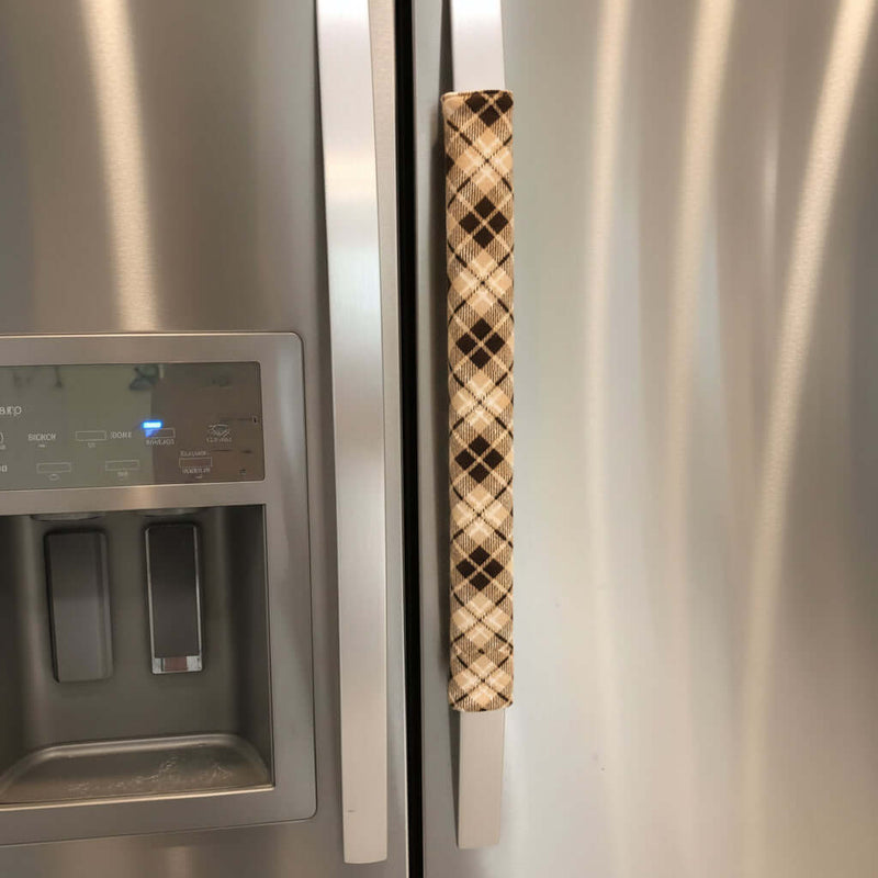 Stainless steel fridge with a brown-and-beige handle cover.