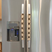 Plaid-patterned handle covers on a refrigerator.