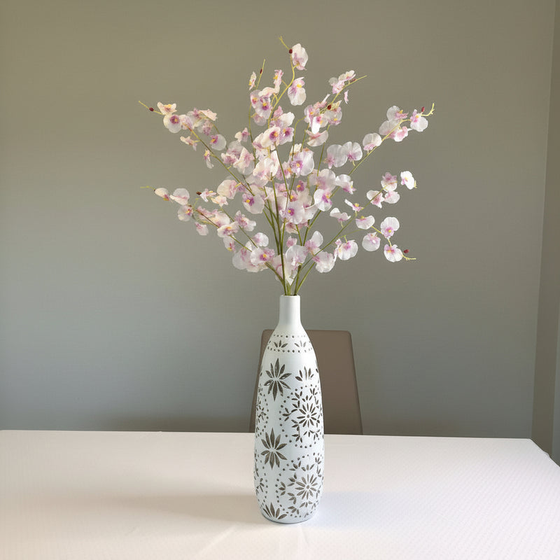 Decorative vase with a floral arrangement on a white surface in front of the stairs