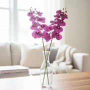 Purple orchid flowers on a table in a living room.