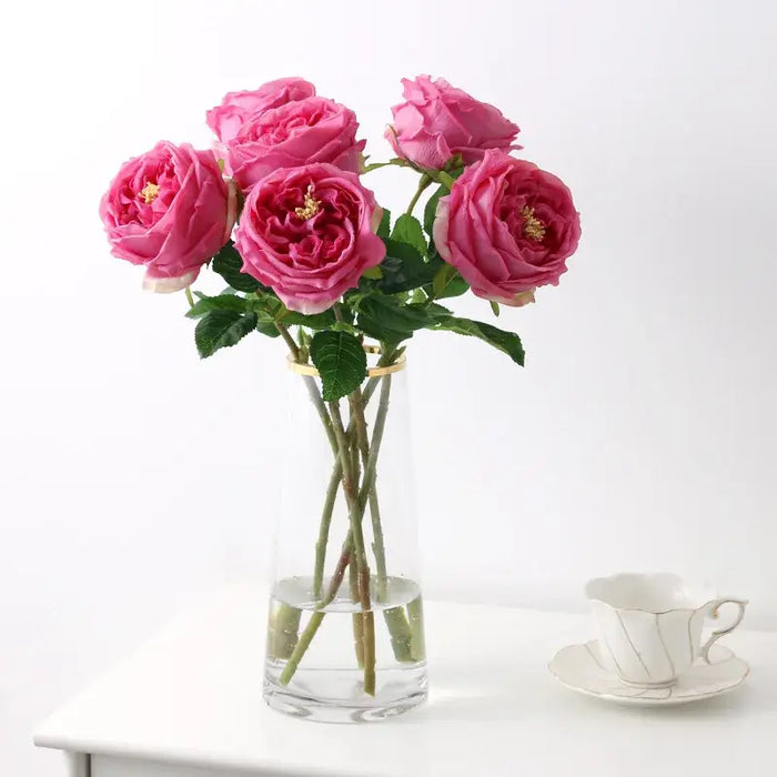 Real Touch Royal Peony Artificial Stem in a vase with pink flowers and green leaves.