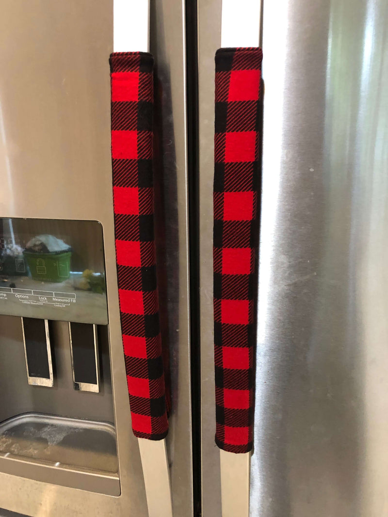 Red and black buffalo check appliance handle covers on refrigerator doors for a rustic kitchen decor.