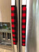 Red and black buffalo check appliance handle covers on refrigerator doors for a rustic kitchen decor.