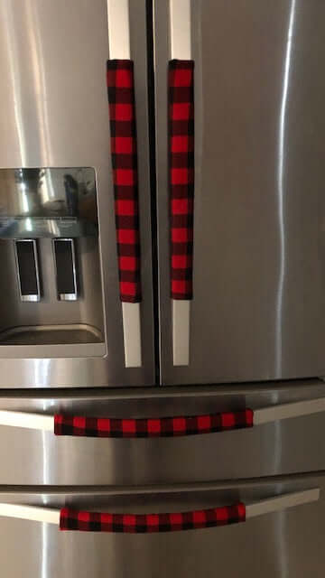 Red and black buffalo check appliance handle covers on a refrigerator, adding rustic farmhouse style and protection.