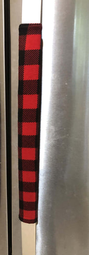 Red and black buffalo check appliance handle covers on a stainless steel refrigerator.