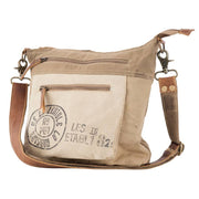 Upcycled canvas shoulder bag in beige with leather straps and functional pockets, perfect for eco-friendly fashion.