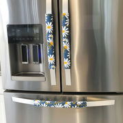 White and Yellow Daisies on Blue Appliance Handle Covers on a stainless steel refrigerator.