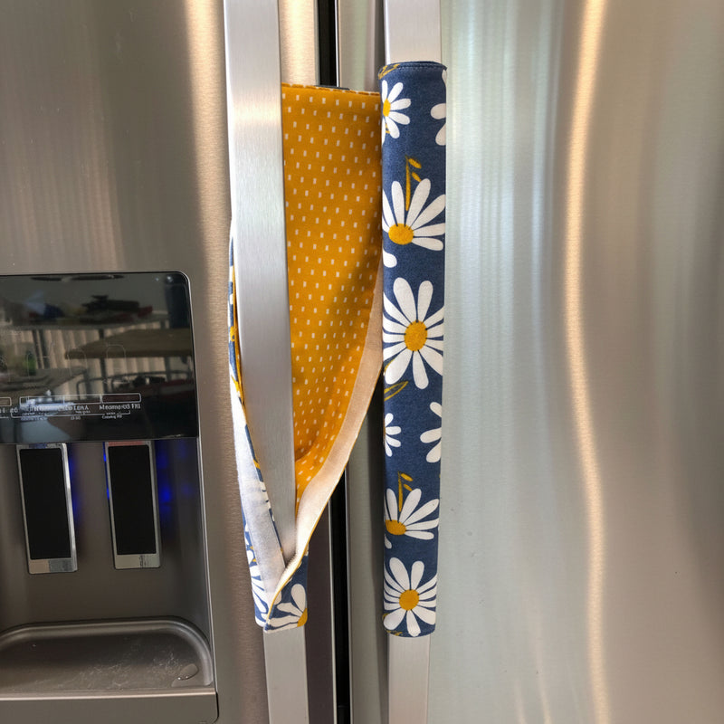 White and Yellow Daisies on Blue Appliance Handle Covers on a refrigerator handle, adding a cheerful touch.