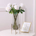 Realistic artificial rose stem in a clear vase with greenery enhancing home decor elegance.