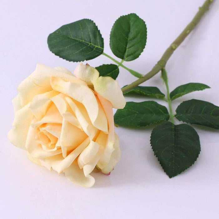 Realistic Artificial Rose Stem in soft yellow with green leaves, perfect for home decor and floral arrangements.